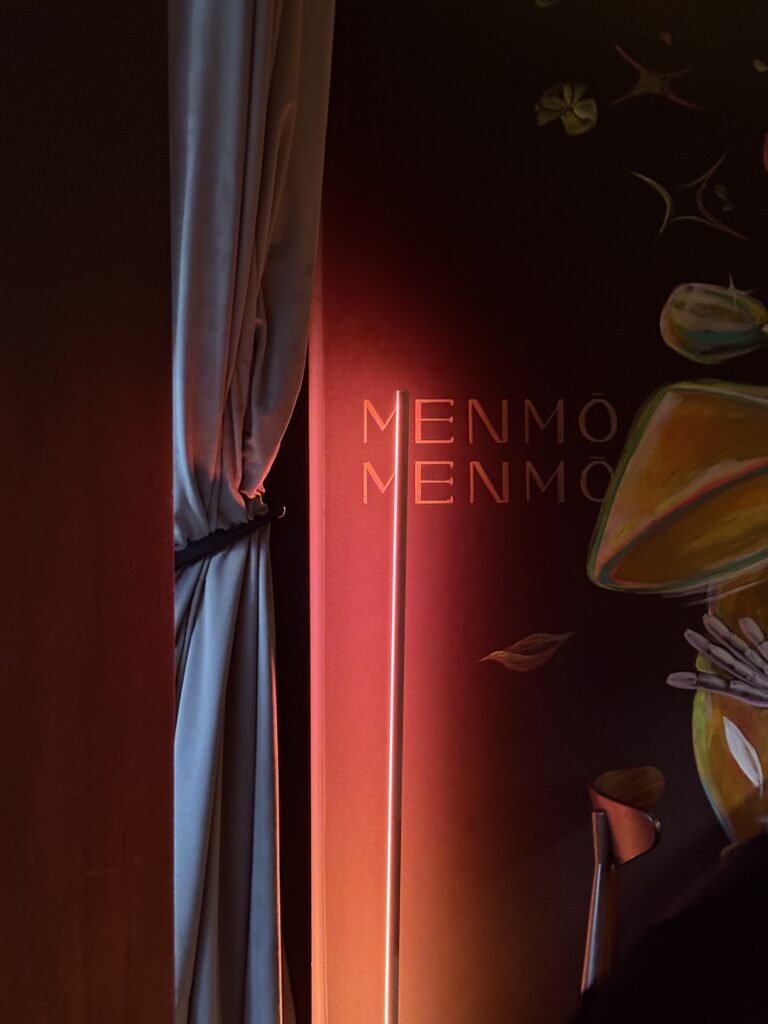 Detailaufnahme eines beleuchteten Wandbereichs im Restaurant mit Vorhang und modernem Lichtdesign.